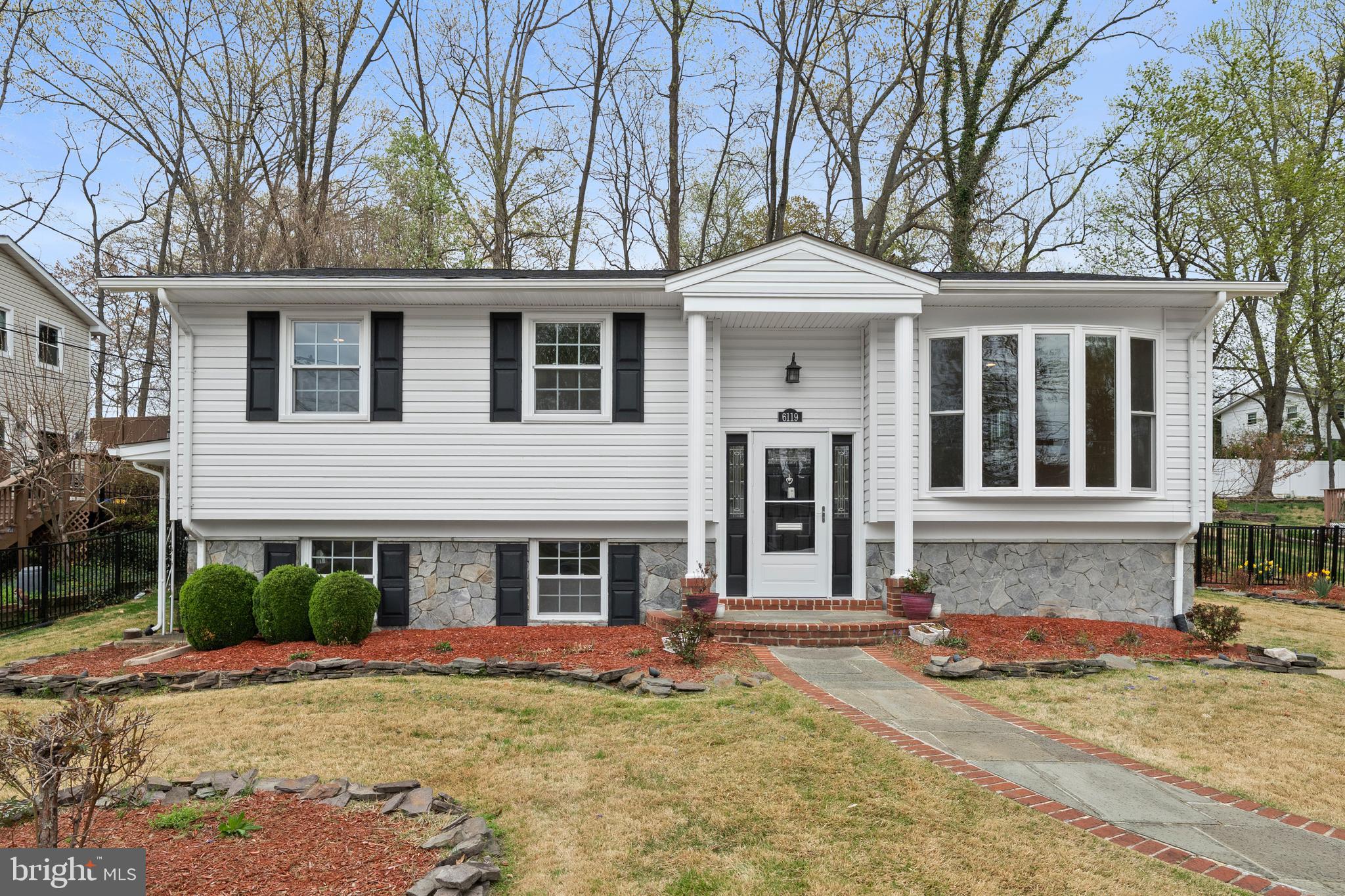 6119 Greeley Boulevard Springfield, VA 22152 - Photo 1 of 38 a front view of a house with a yard and garage