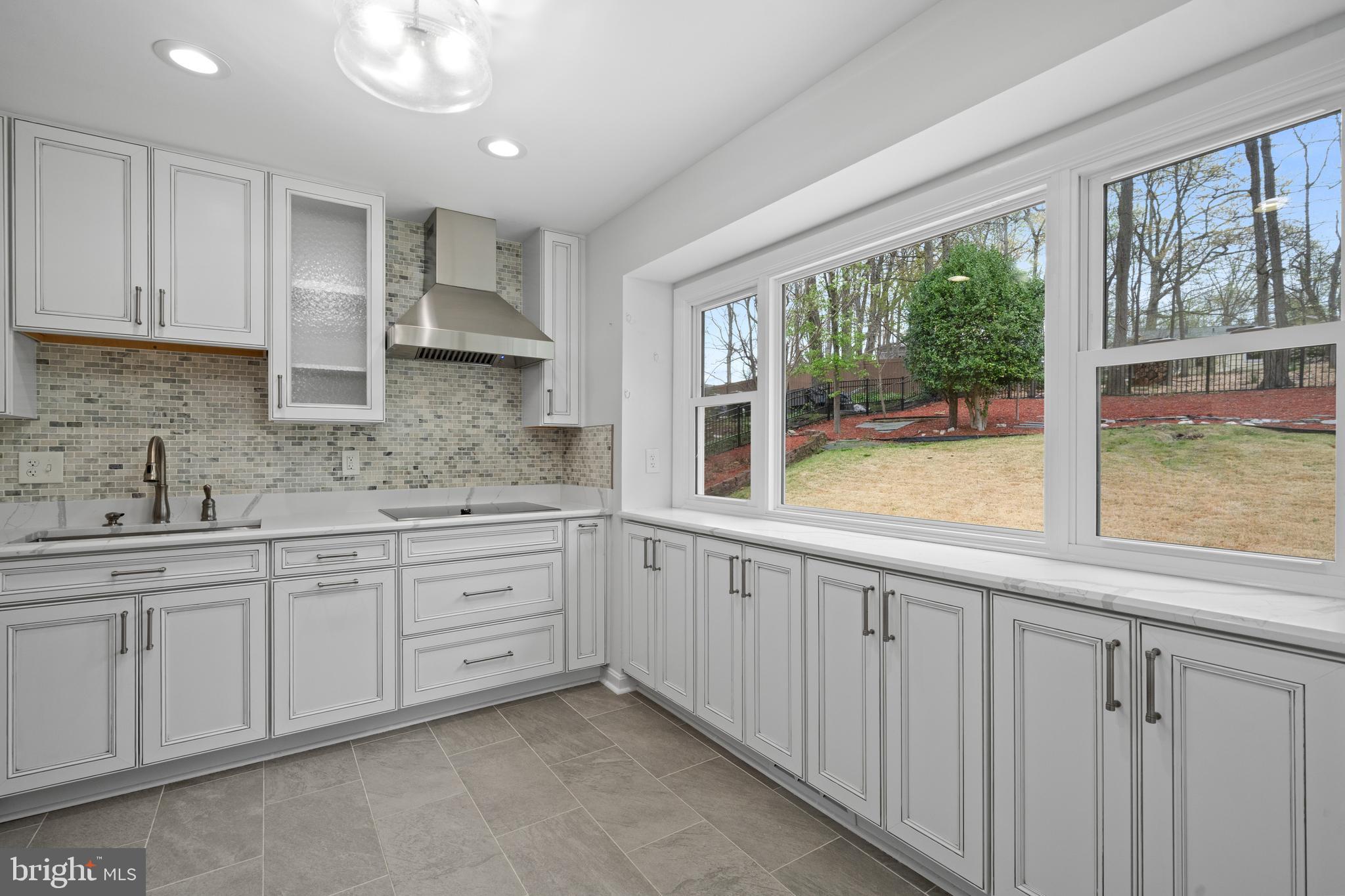 6119 Greeley Boulevard Springfield, VA 22152 - Photo 13 of 38 a large kitchen with a large window and stainless steel appliances