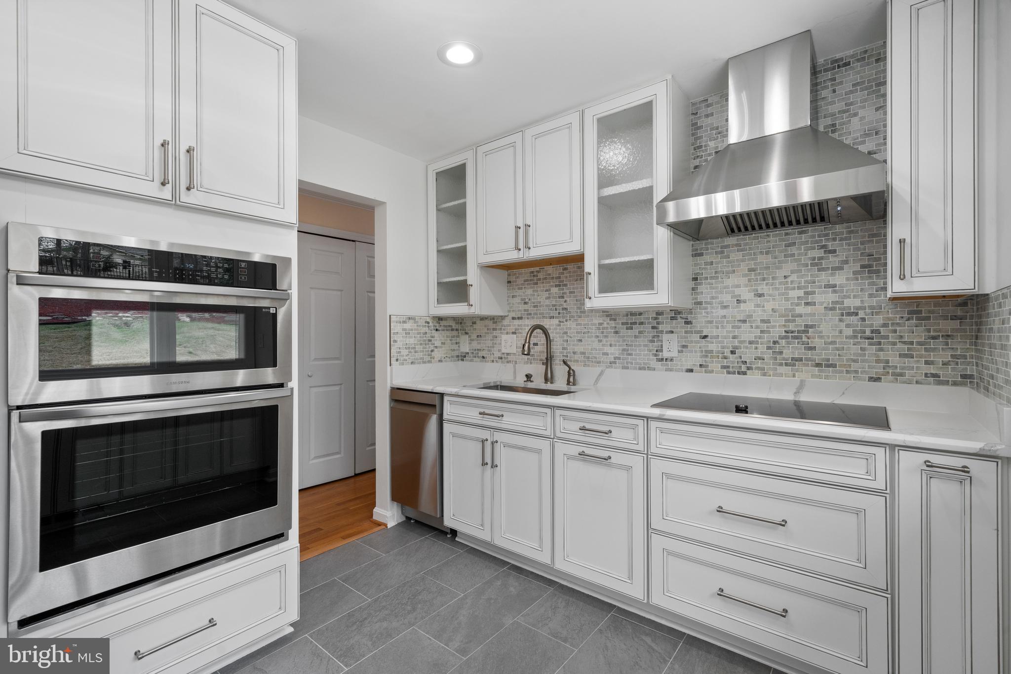 6119 Greeley Boulevard Springfield, VA 22152 - Photo 14 of 38 a kitchen with white cabinets stainless steel appliances and sink