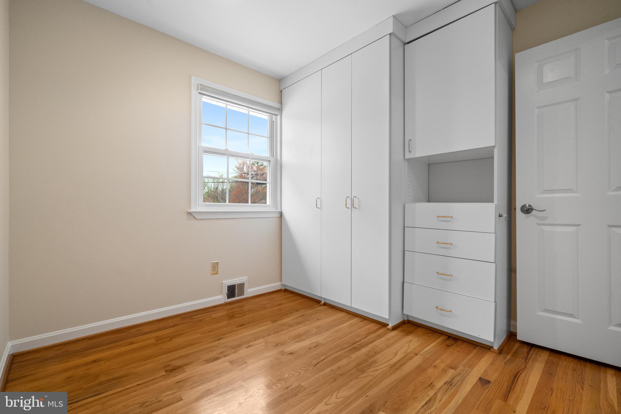 6119 Greeley Boulevard Springfield, VA 22152 - Photo 19 of 38 an empty room with wooden floor and windows