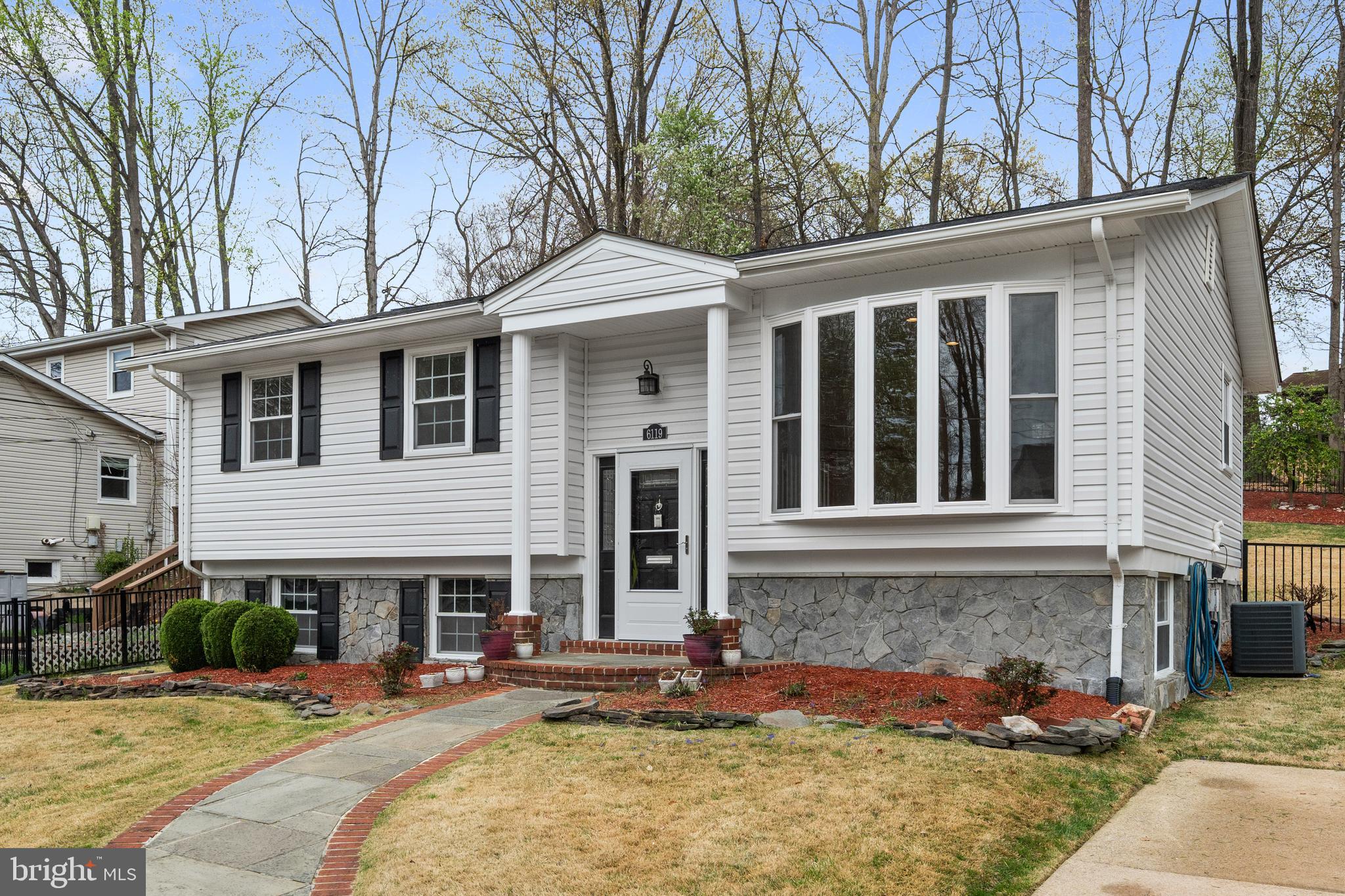 6119 Greeley Boulevard Springfield, VA 22152 - Photo 2 of 38 a front view of a house with a yard