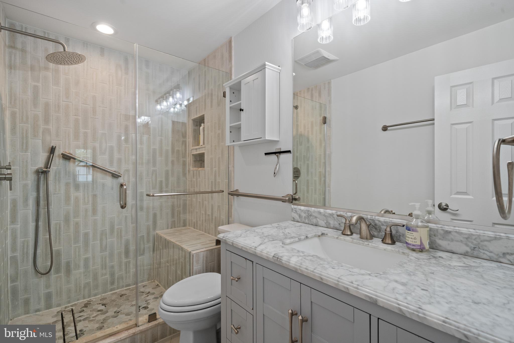 6119 Greeley Boulevard Springfield, VA 22152 - Photo 21 of 38 a bathroom with a granite countertop sink a toilet and shower