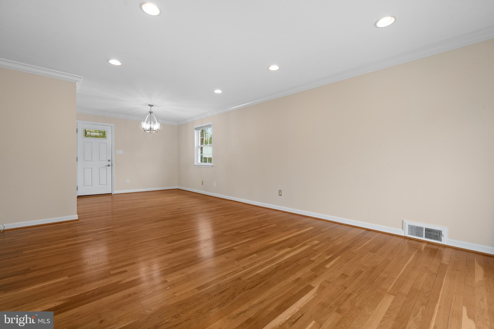6119 Greeley Boulevard Springfield, VA 22152 - Photo 5 of 38 an empty room with wooden floor and natural light