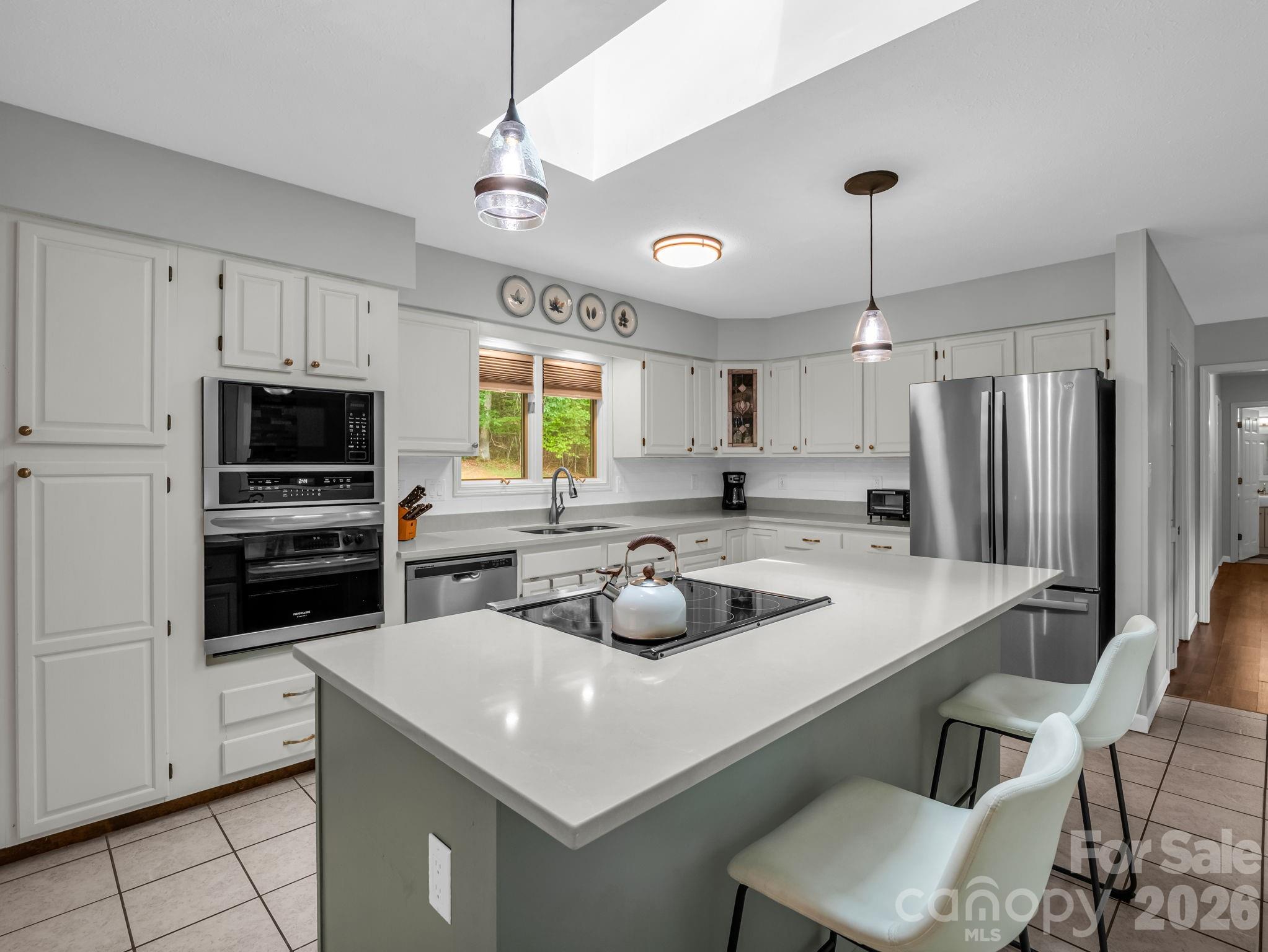 656 Cashiers Valley Road Brevard, NC 28712 - Photo 9 of 37 a kitchen that has a sink a center island stainless steel appliances and cabinets