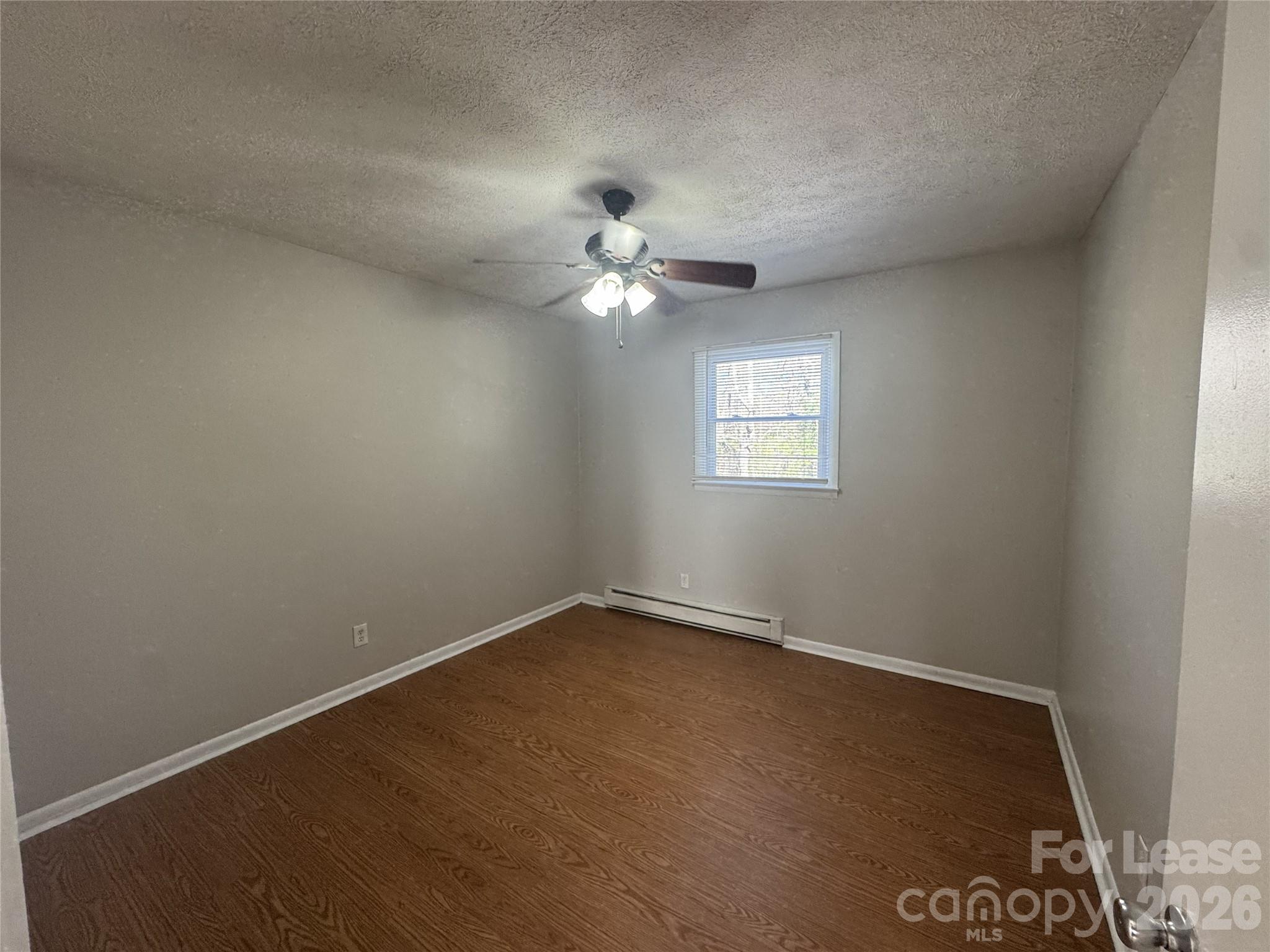 341 Laurel Street Hudson, NC 28638 - Photo 8 of 8 an empty room with windows and fan
