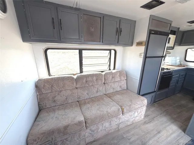 a kitchen with stainless steel appliances a refrigerator sink and wooden floor