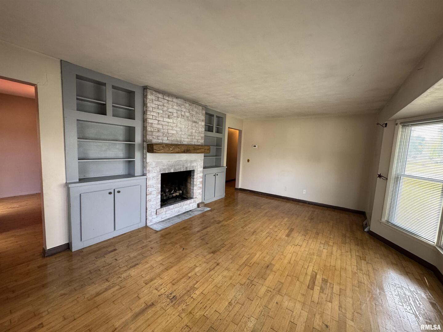 7 Holly Lane Flora, IL 62839 - Photo 7 of 42 an empty room with a fireplace and window