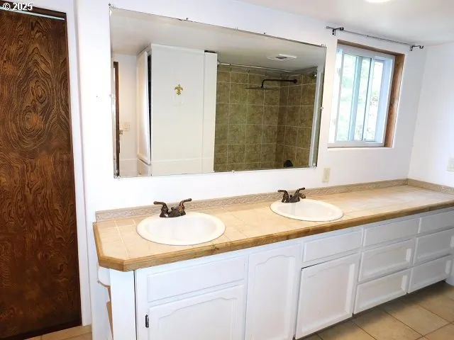 a bathroom with double sink and a mirror