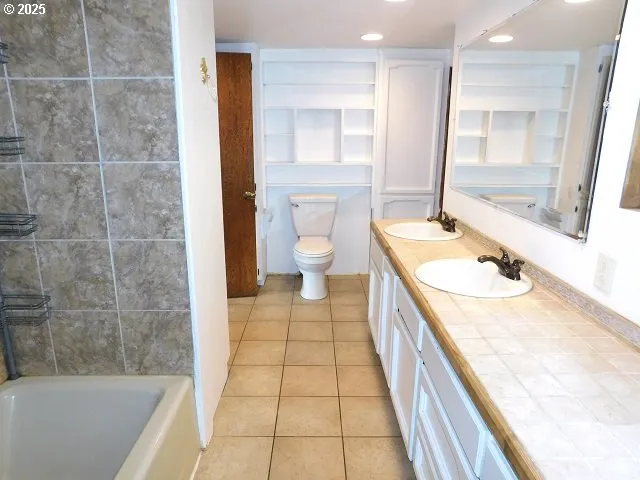 a bathroom with a granite countertop sink a toilet a mirror and bathtub