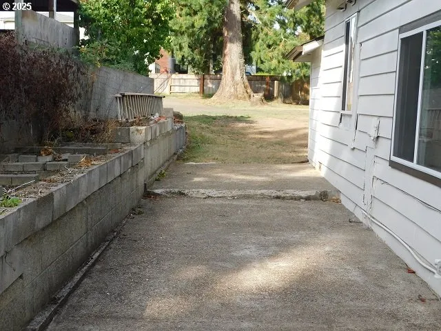a view of a backyard with table and chairs under a large tree