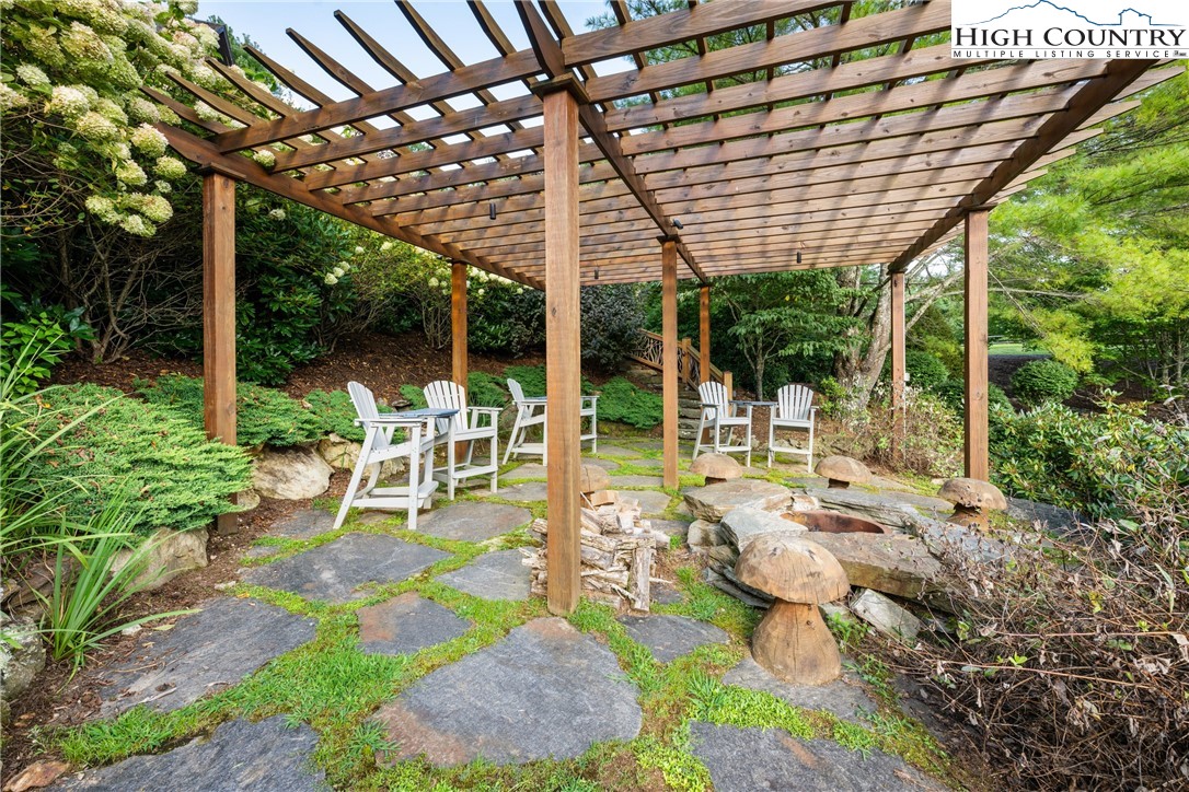 333 Windy Ridge Road Vilas, NC 28692 - Photo 43 of 46 a view of a patio with table and chairs potted plants and large tree