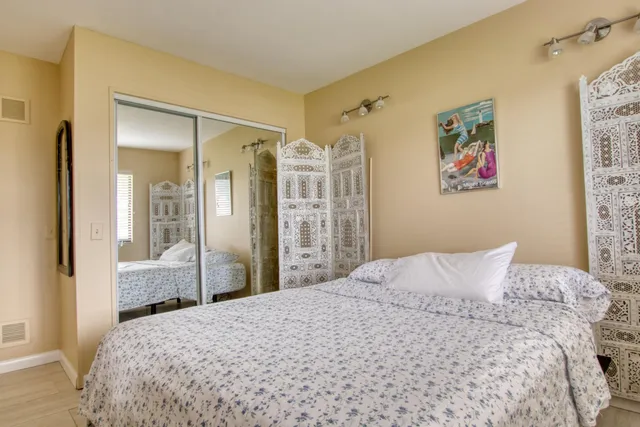 a bedroom with a large bed and a chandelier