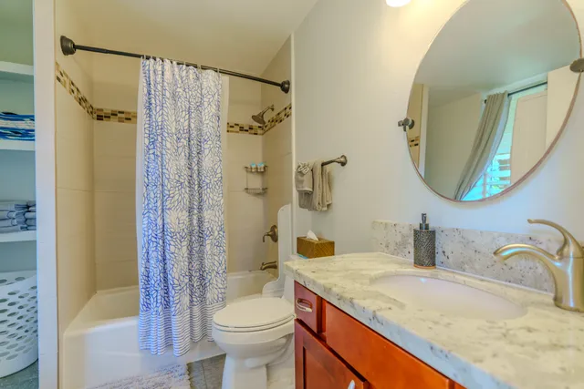 a bathroom with a granite countertop sink toilet and shower