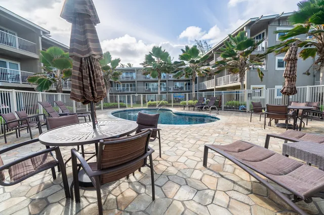 a view of a patio with couches table and chairs and potted plants
