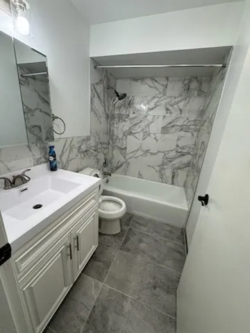 a bathroom with a double vanity sink toilet and shower