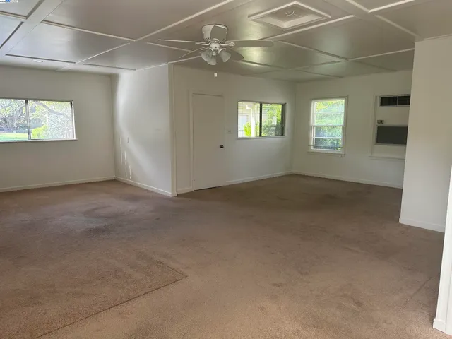 a view of a patio with couches table and chairs under an umbrella