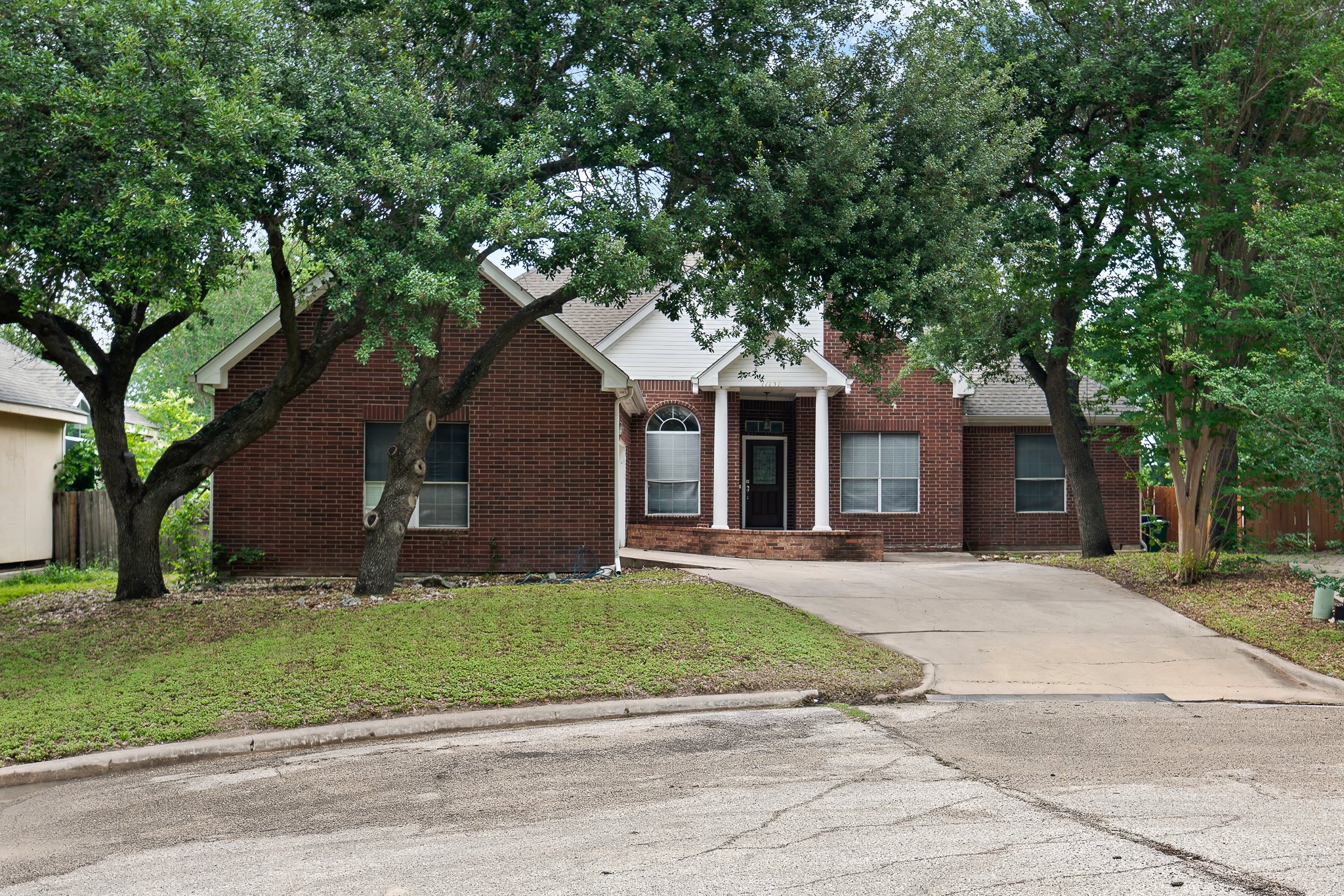 11737 Rydalwater Lane Austin, TX 78754 - Photo 2 of 40 Brick exterior residence with a prominent covered entry featuring white columns