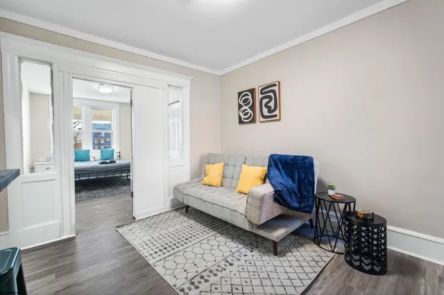 a living room with furniture and a wooden floor
