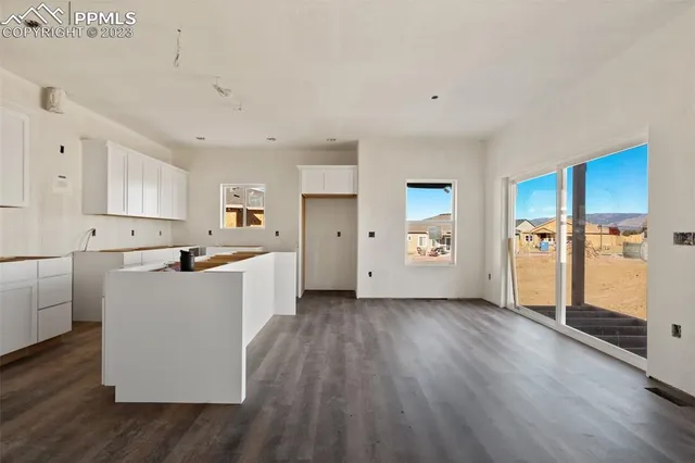 a kitchen with wooden floors and white cabinets