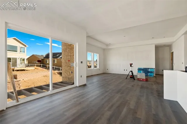 a view of a livingroom with wooden floor and a fireplace