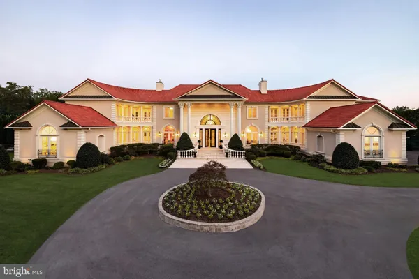 a view of a white house with a yard and potted plants