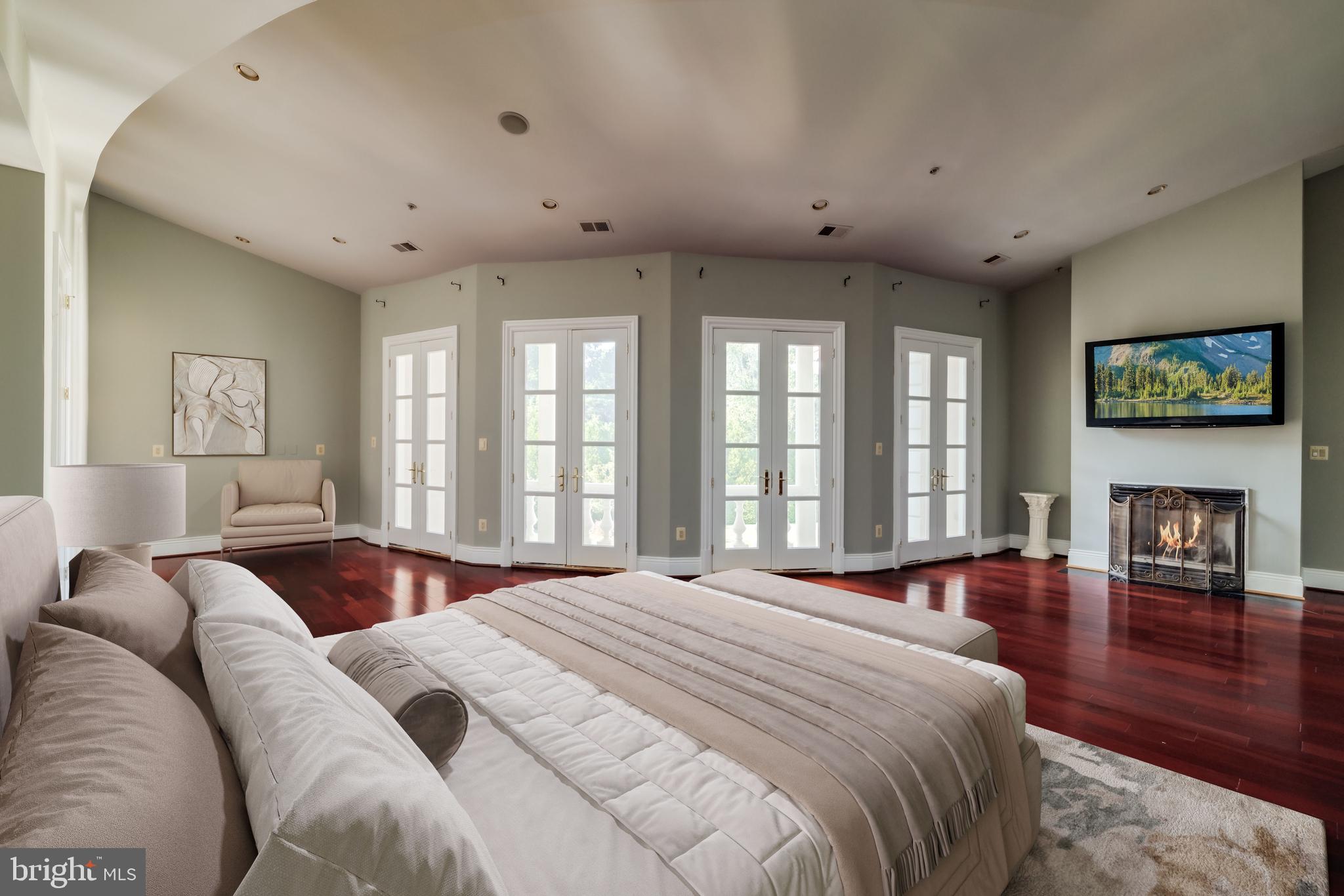 9431 Newbridge Drive Potomac, MD 20854 - Photo 36 of 50 a spacious bedroom with a large bed and a fireplace