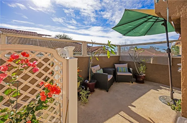 a view of a patio with couches chairs and a umbrella
