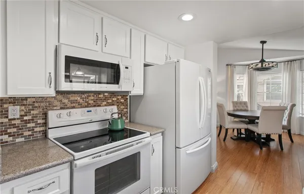 a kitchen with stainless steel appliances a stove a microwave and a hard wood floors