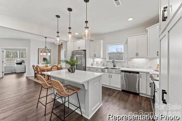 a kitchen with center island white cabinets and white appliances