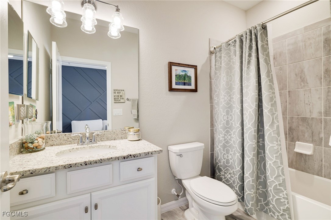 9778 Mirada Boulevard Fort Myers, FL 33908 - Photo 21 of 29 a bathroom with a granite countertop sink a toilet and a mirror