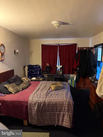 a bedroom with a bed a dresser and a walk in closet