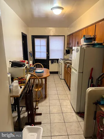 a kitchen with refrigerator and chairs