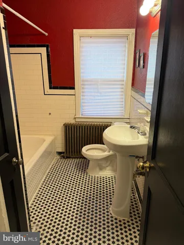 a bathroom with a sink a toilet a mirror and shower