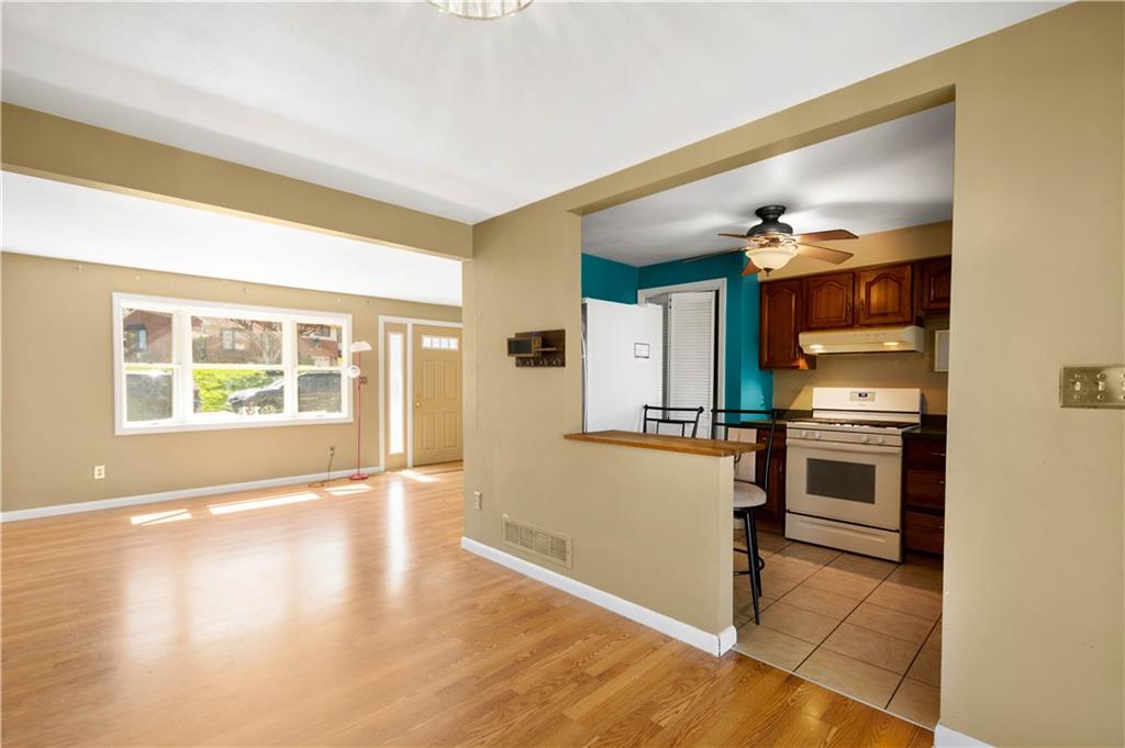 169 Balver Avenue Pittsburgh, PA 15205 - Photo 7 of 24 a view of a kitchen with a stove wooden cabinets and a living room view