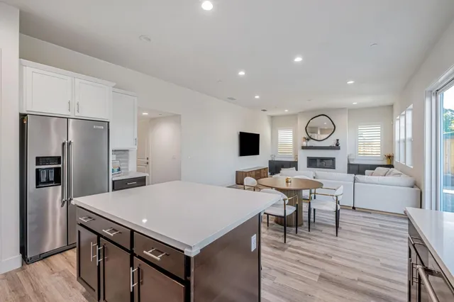 a kitchen with a table chairs refrigerator and microwave