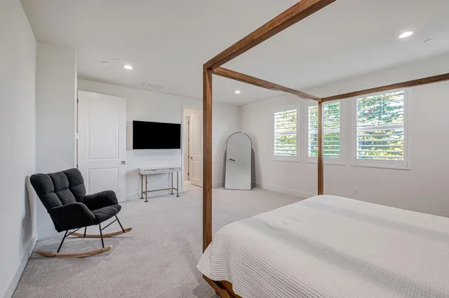 a spacious bedroom with a bed and a flat screen tv