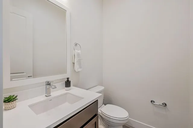 a bathroom with a sink a toilet and mirror