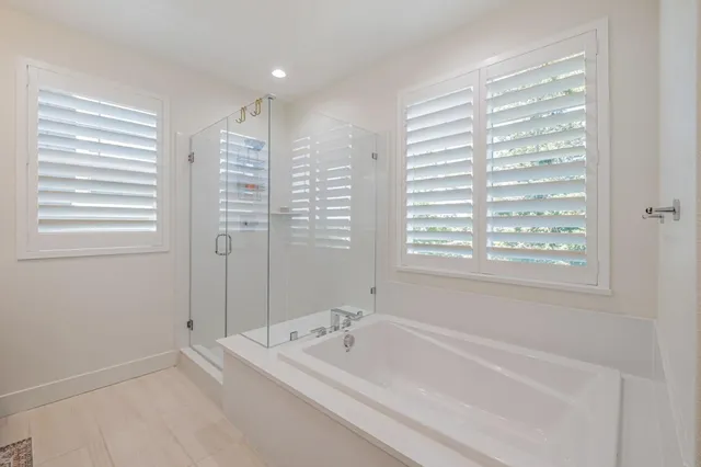 a spacious bathroom with bathtub and a shower