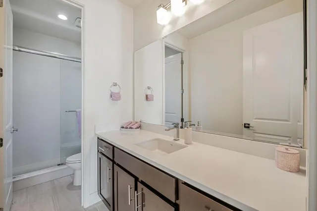 a bathroom with a sink a toilet and shower