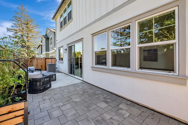 a view of a house with a barbeque next to a yard
