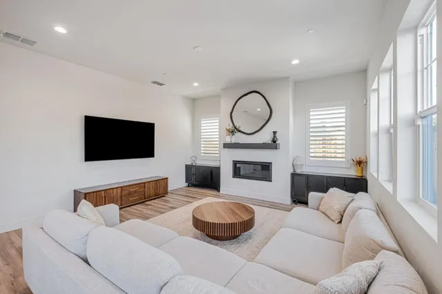 a living room with furniture a flat screen tv and a fireplace