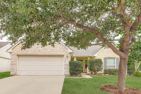 a front view of a house with a yard and trees