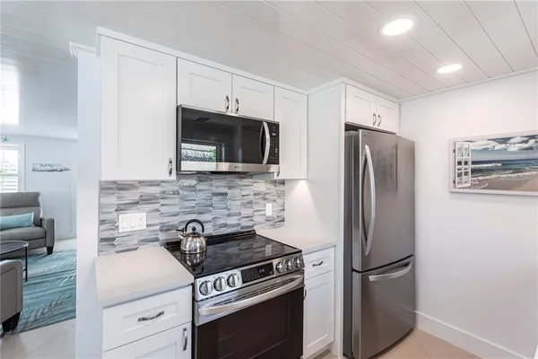 a kitchen with stainless steel appliances a refrigerator stove and microwave