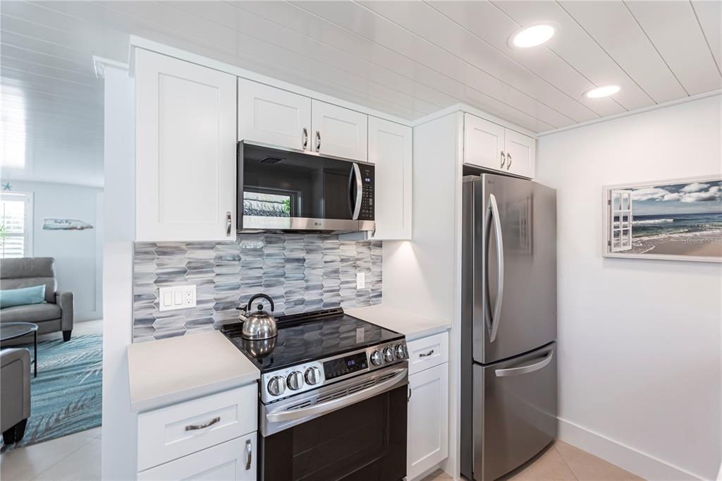 6154 Midnight Pass Road, Unit A1 Sarasota, FL 34242 - Photo 11 of 19 a kitchen with stainless steel appliances a refrigerator stove and microwave