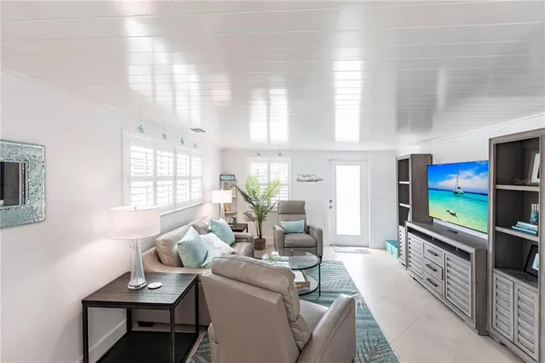 a living room with furniture a flat screen tv and a window