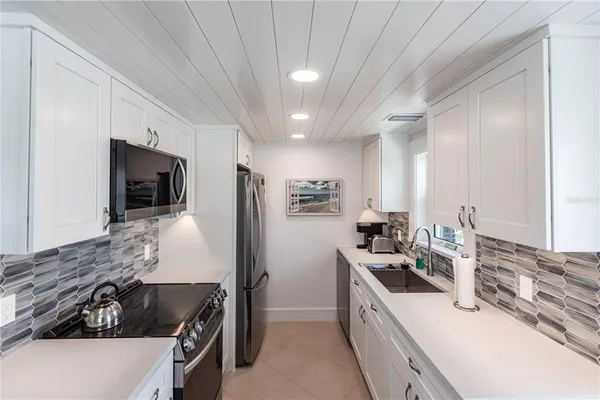 a kitchen with stainless steel appliances a sink stove and refrigerator