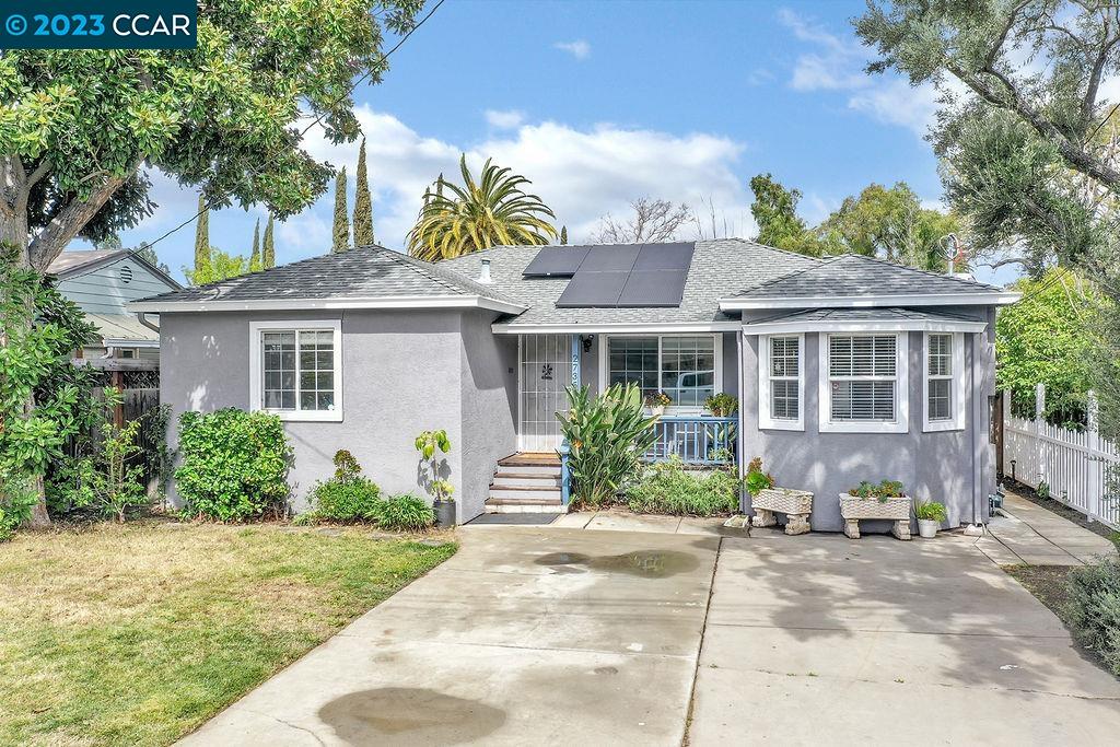 a front view of a house with a garden and plants