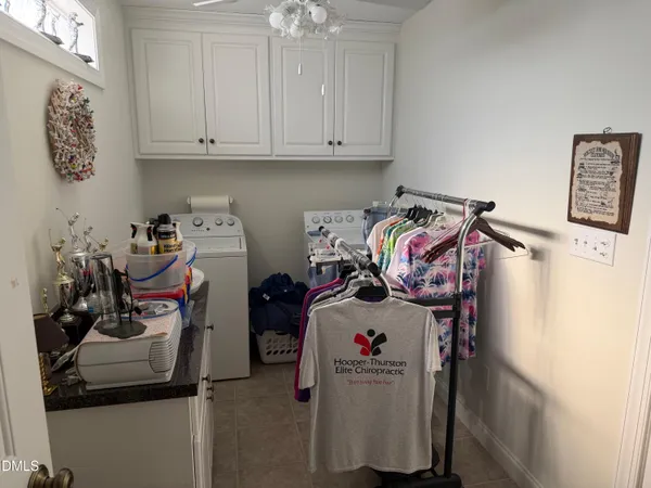 a utility room with fridge dryer and washer