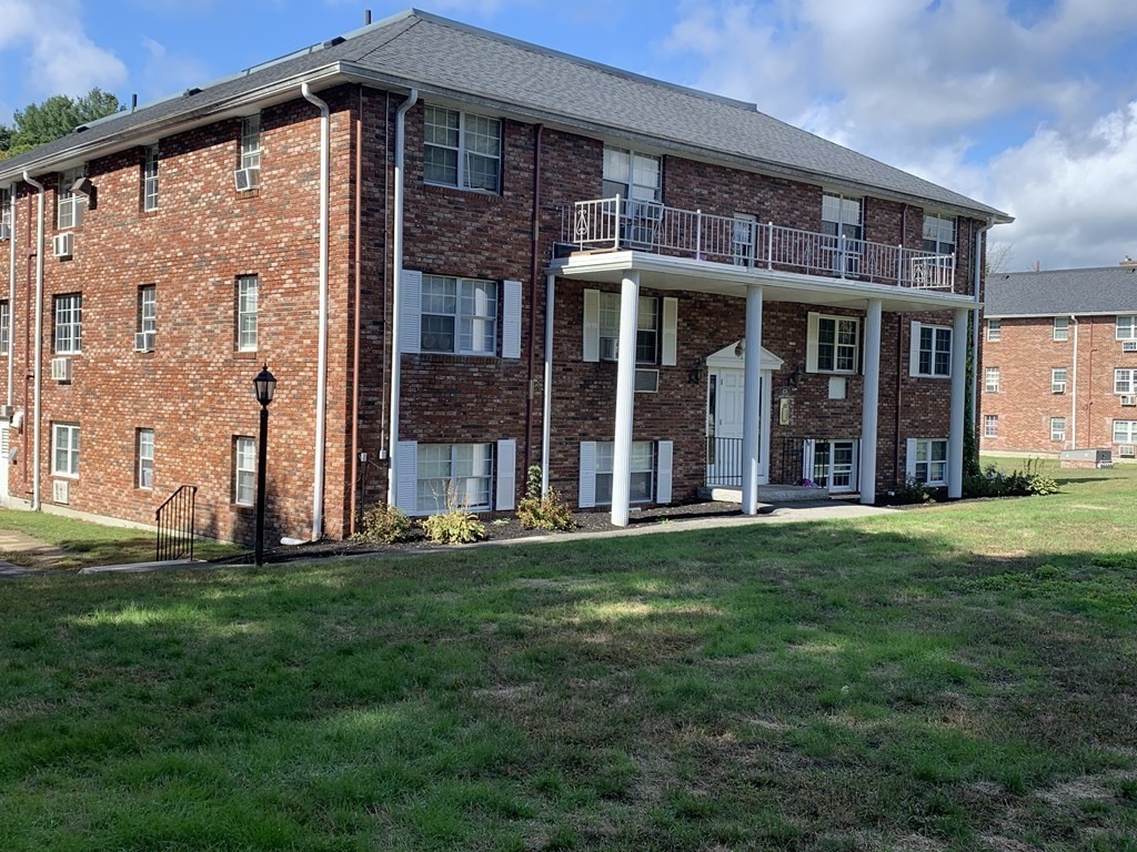 424 Great Road, Unit 2 Acton, MA 01720 - Photo 2 of 13 front view of a brick house with a yard