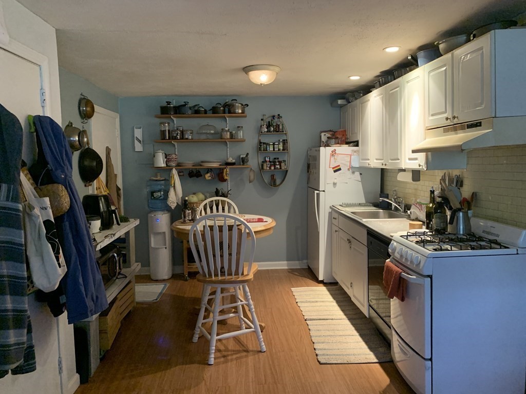 424 Great Road, Unit 2 Acton, MA 01720 - Photo 3 of 13 a kitchen with stainless steel appliances kitchen island granite countertop a refrigerator and a sink